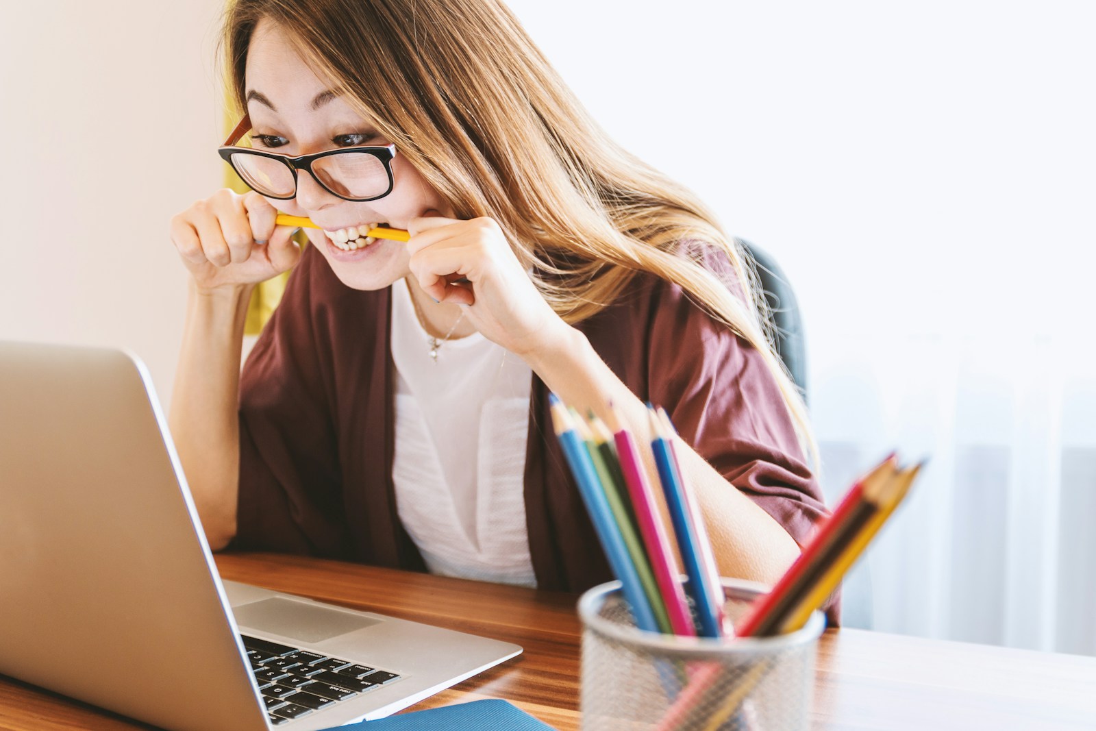 woman facing Business growth challenges biting pencil while sitting on chair in front of computer during daytime